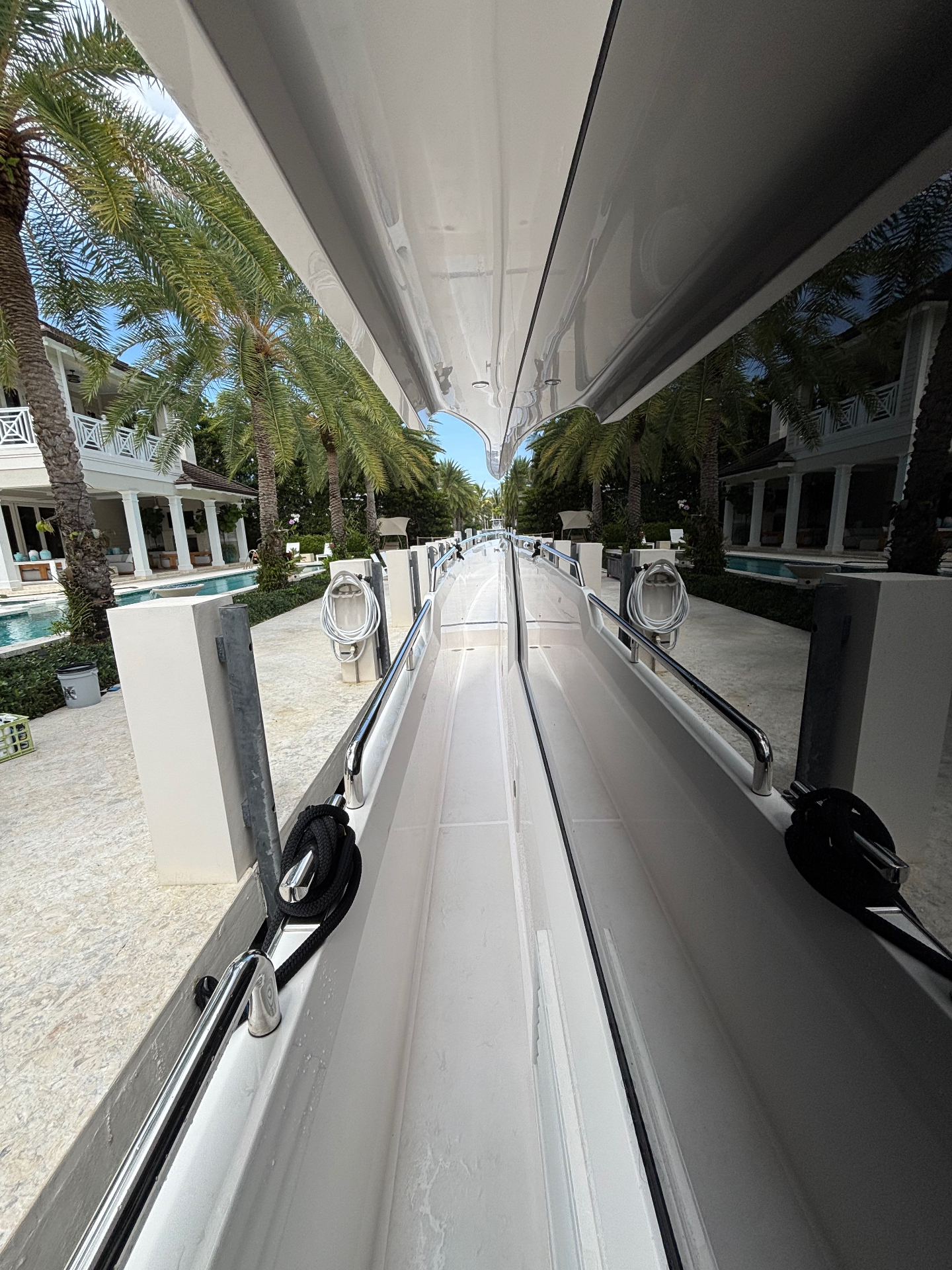 Mirror-finish gunwale reflecting the marina, palms and all.